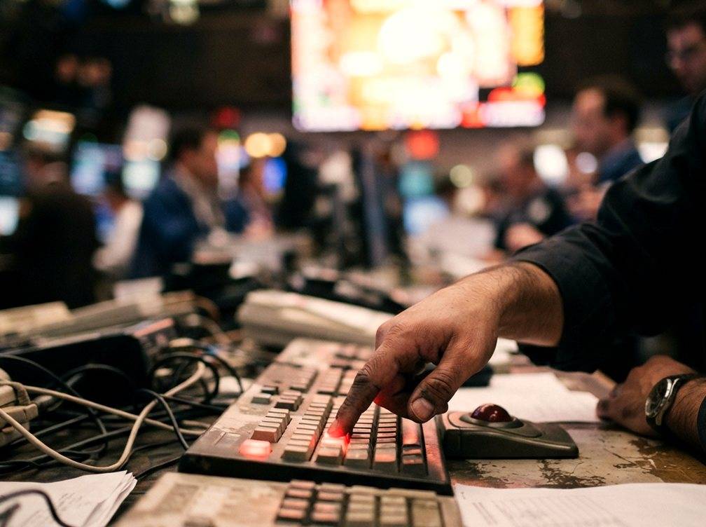 A trader's hand at a terminal during the stock market opening bell.